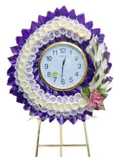 พวงหรีดนาฬิกา สีม่วงประดับด้วยดอกไม้สีขาว