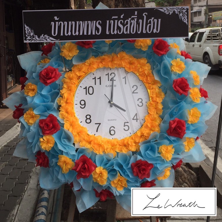 พวงหรีดนาฬิกาตกแต่งด้วยดอกไม้ประดิษฐ์หลากสีสันอย่างสวยงาม ช่วยบรรเทาความโศกเศร้าได้เป็นอย่างดี