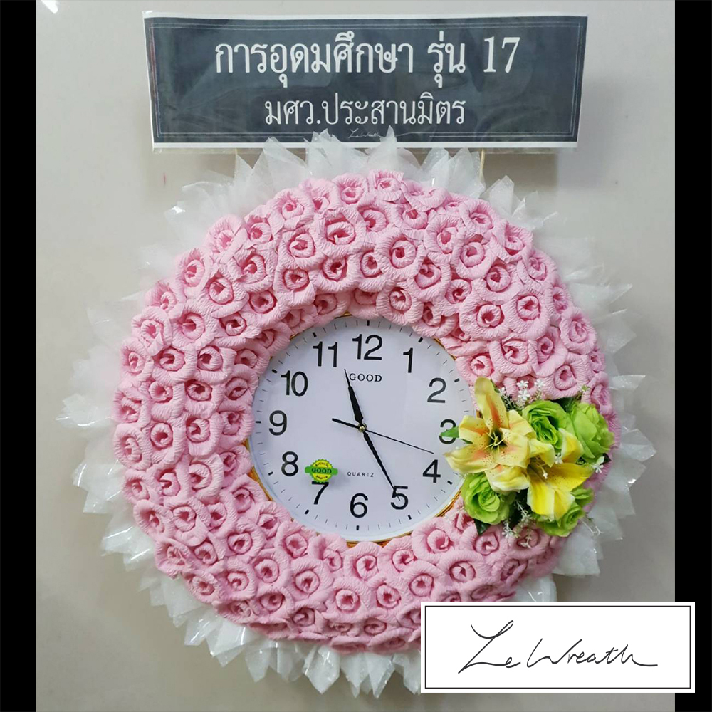 พวงหรีดนาฬิกาโทนสีชมพู ตกแต่งด้วยดอกไม้จันทน์อย่างสวยงาม สามารถนำไปบริจาคหรือใช้ประโยชน์ต่อได้หลังเสร็จพิธี