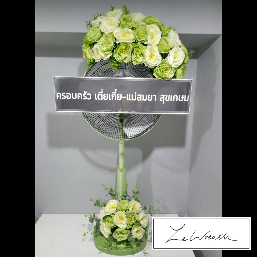 พวงหรีดพัดลมขนาด 16 นิ้ว ตกแต่งด้วยดอกกุหลาบประดิษฐ์สีขาวและเขียวอย่างสวยงาม เหมาะสำหรับแสดงความอาลัยผู้อาวุโส
