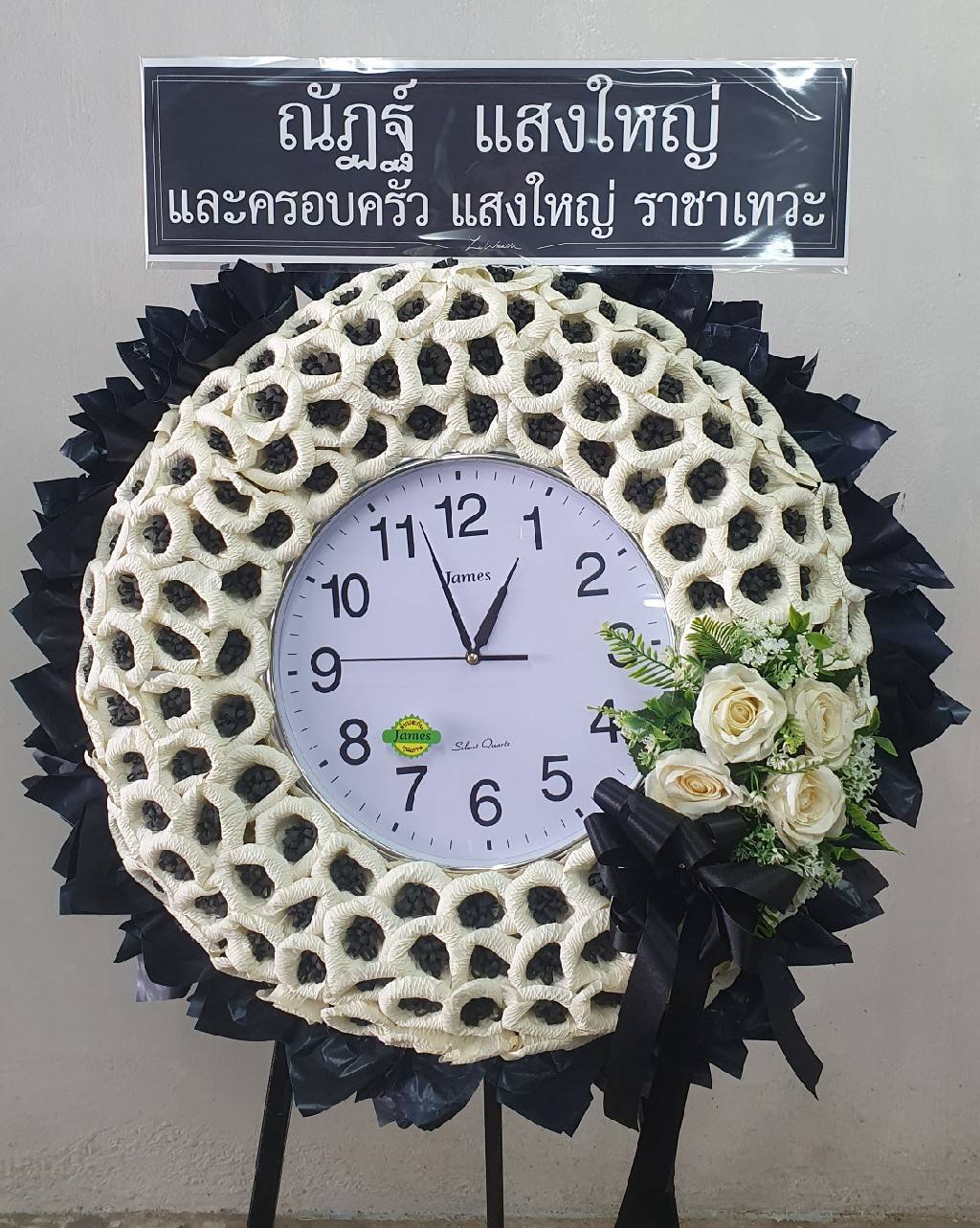 พวงหรีดดอกไม้จันทน์นาฬิกา โทนสีหวานพาสเทล นำนาฬิกาขนาดเส้นผ่านศูนย์กลางประมาณ 60-80 ซม. มาตกแต่งดอกไม้จันทน์สีชมพูอ่อน ตัดกับพื้นหลังสีฟ้า