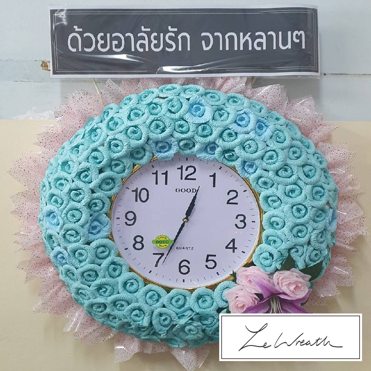 พวงหรีดนาฬิกาตกแต่งอย่างสวยงามด้วยดอกไม้จันทน์ประดิษฐ์โทนสีฟ้า เหมาะแก่การไว้อาลัยทุกประเภท
