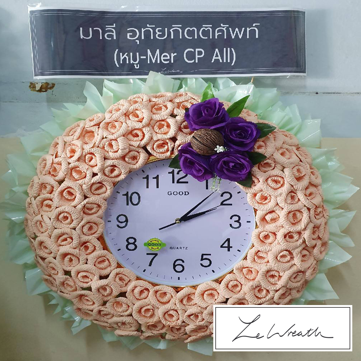 พวงหรีดนาฬิกาตกแต่งด้วยดอกไม้จันทน์โทนสีส้ม ใช้ประโยชน์ได้หลังเสร็จสิ้นพิธีศพ